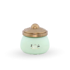 Light green ceramic jar with a gold lid on a white background
