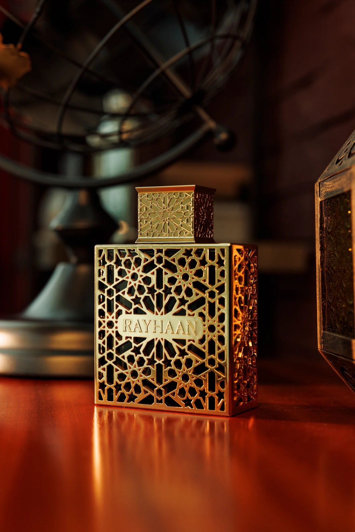 Rayhaan Elixir Eau de Parfum 100ml bottle on a table in warm light – unisex perfume, notes of benzoin, tonka bean and bergamot