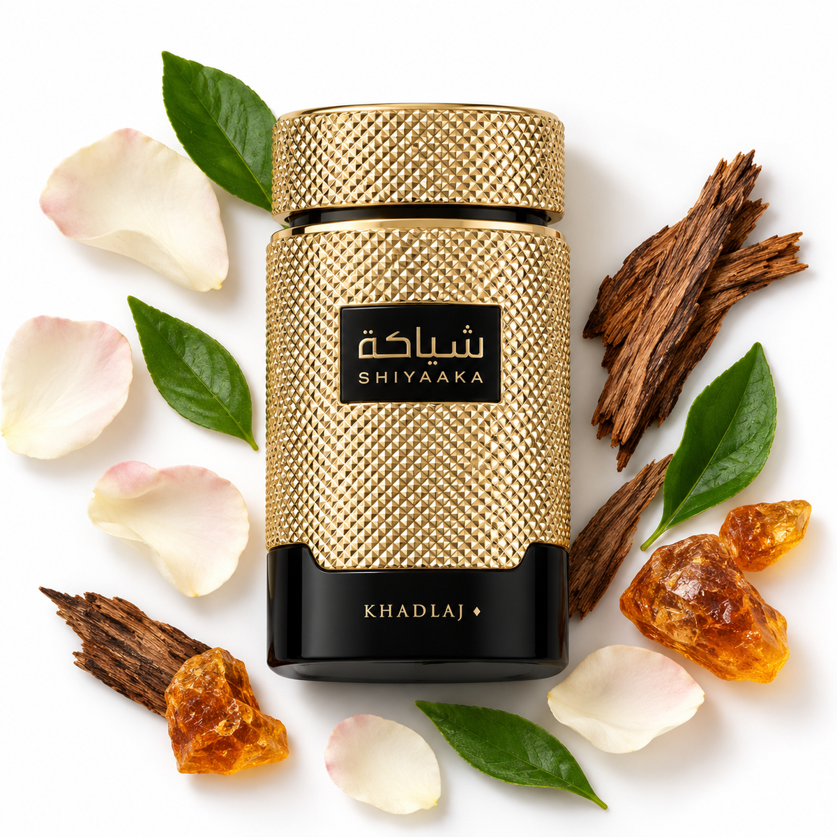 Khadlaj Shiyaaka Gold 100ml bottle on white with floral petals, green leaves, wood and amber resin
