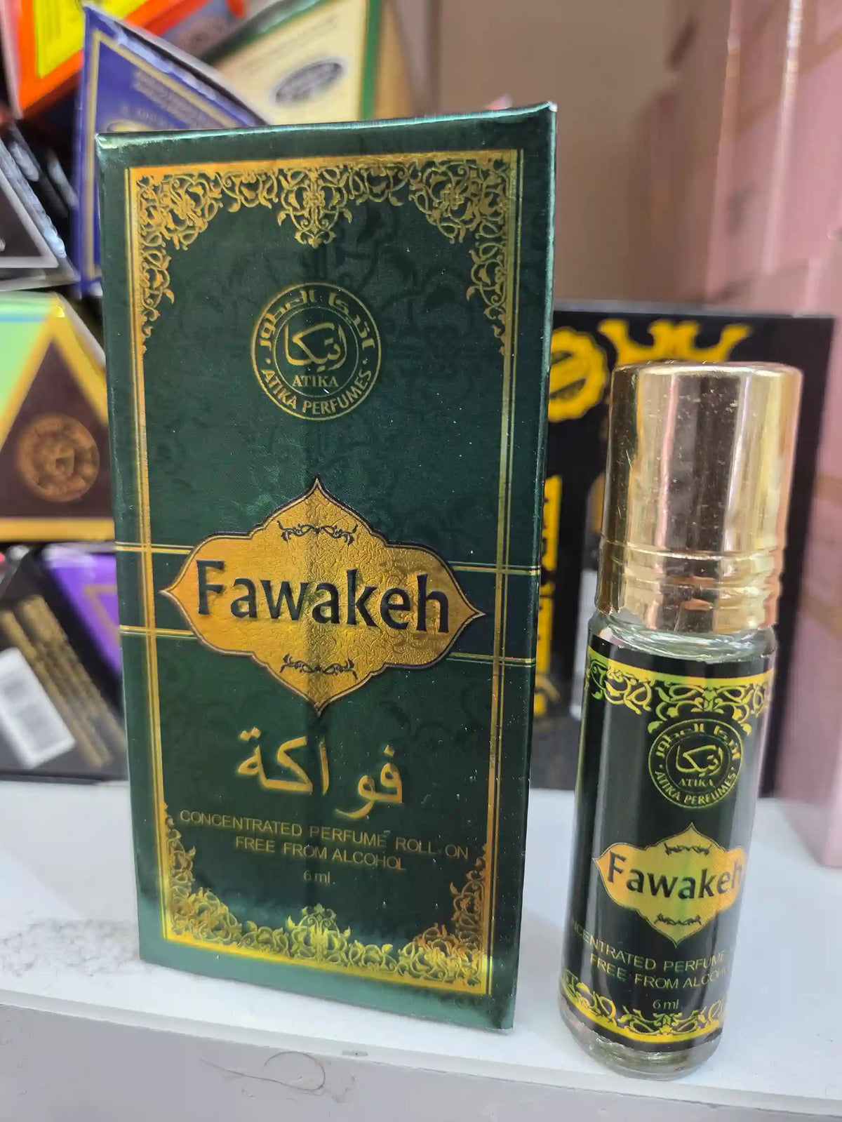 Fawakeh roll-on perfume bottle with green and gold Arabic packaging by Atika Perfumes