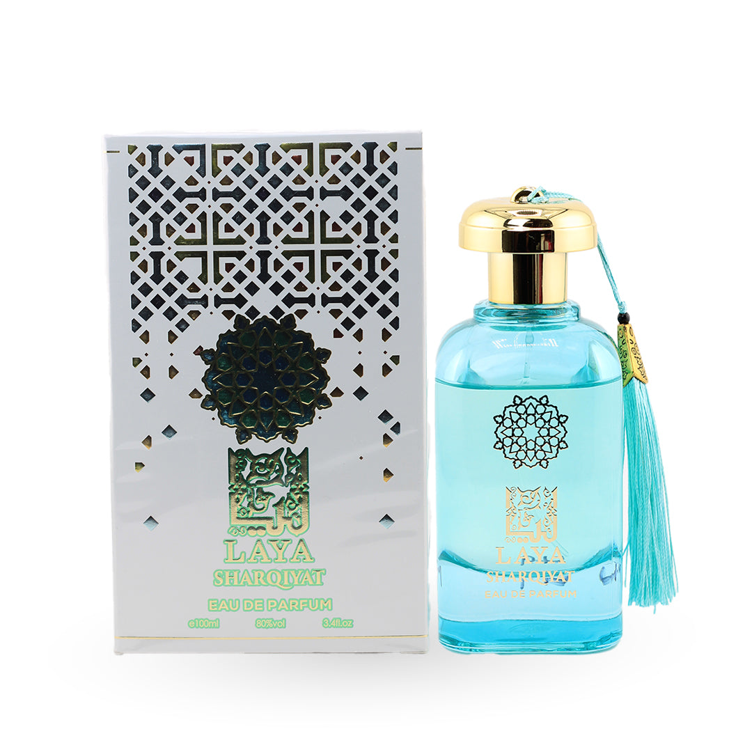 Blue perfume bottle with gold cap and tassel next to its packaging on a white background
