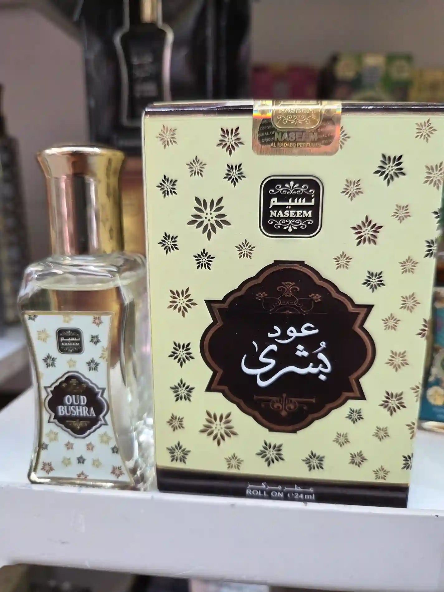 Naseem Oud Bushra roll-on perfume oil with cream and gold star packaging