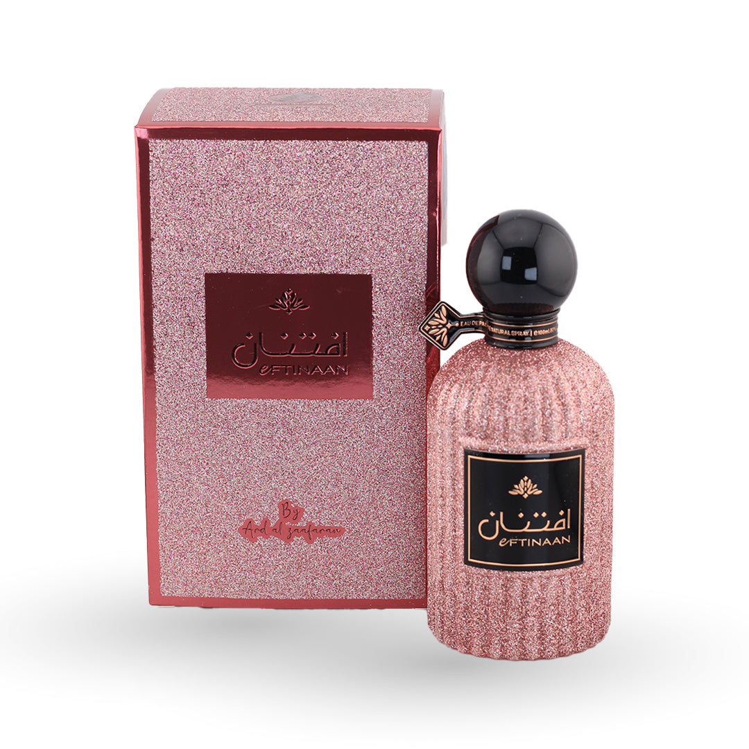Pink perfume bottle with black cap and matching box on a white background