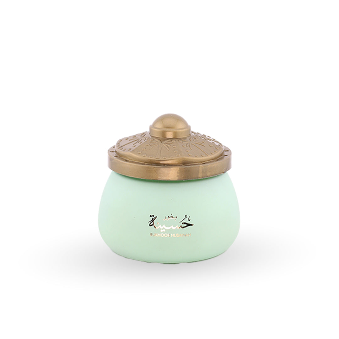 Light green ceramic jar with a gold lid on a white background
