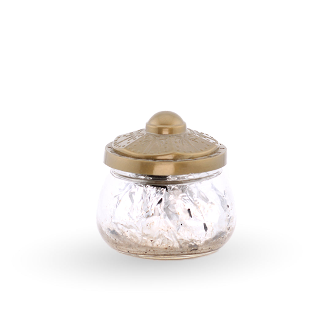 Glass jar with a gold lid on a white background