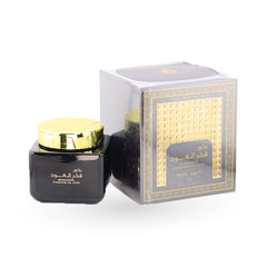 Black jar with gold lid and decorative box on a white background