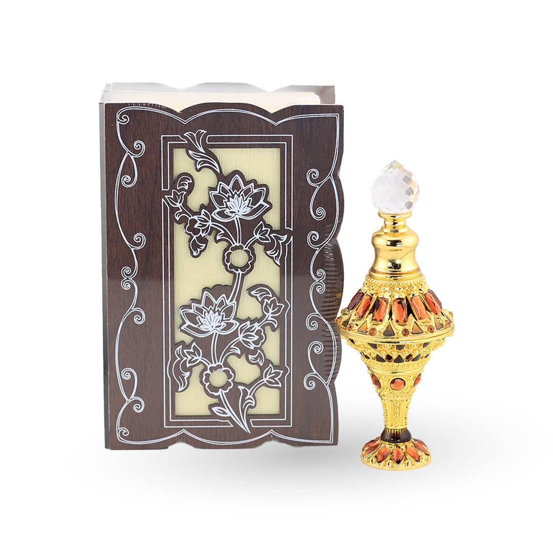 Decorative bottle with intricate design next to an ornate box with floral patterns on a white background